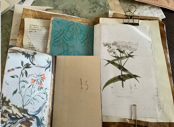 A junk journal being created with lots of papers on a desk