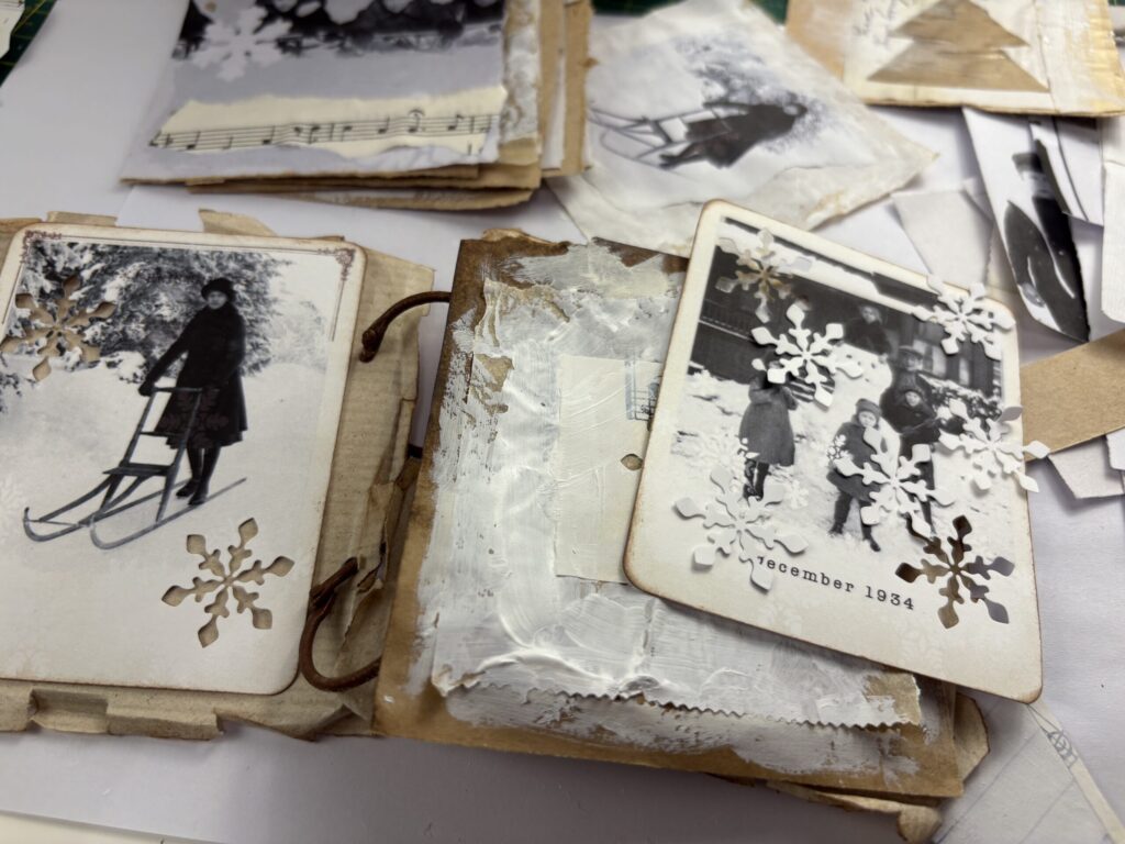 Making a winter junk journal with brown paper pages painted white and layered with black and white Polaroids